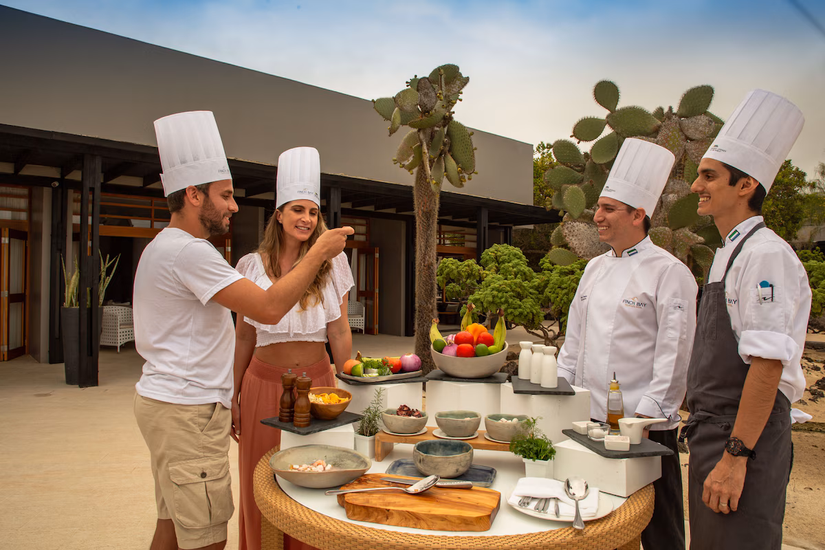 Chefs preparing a fresh outdoor meal with guests